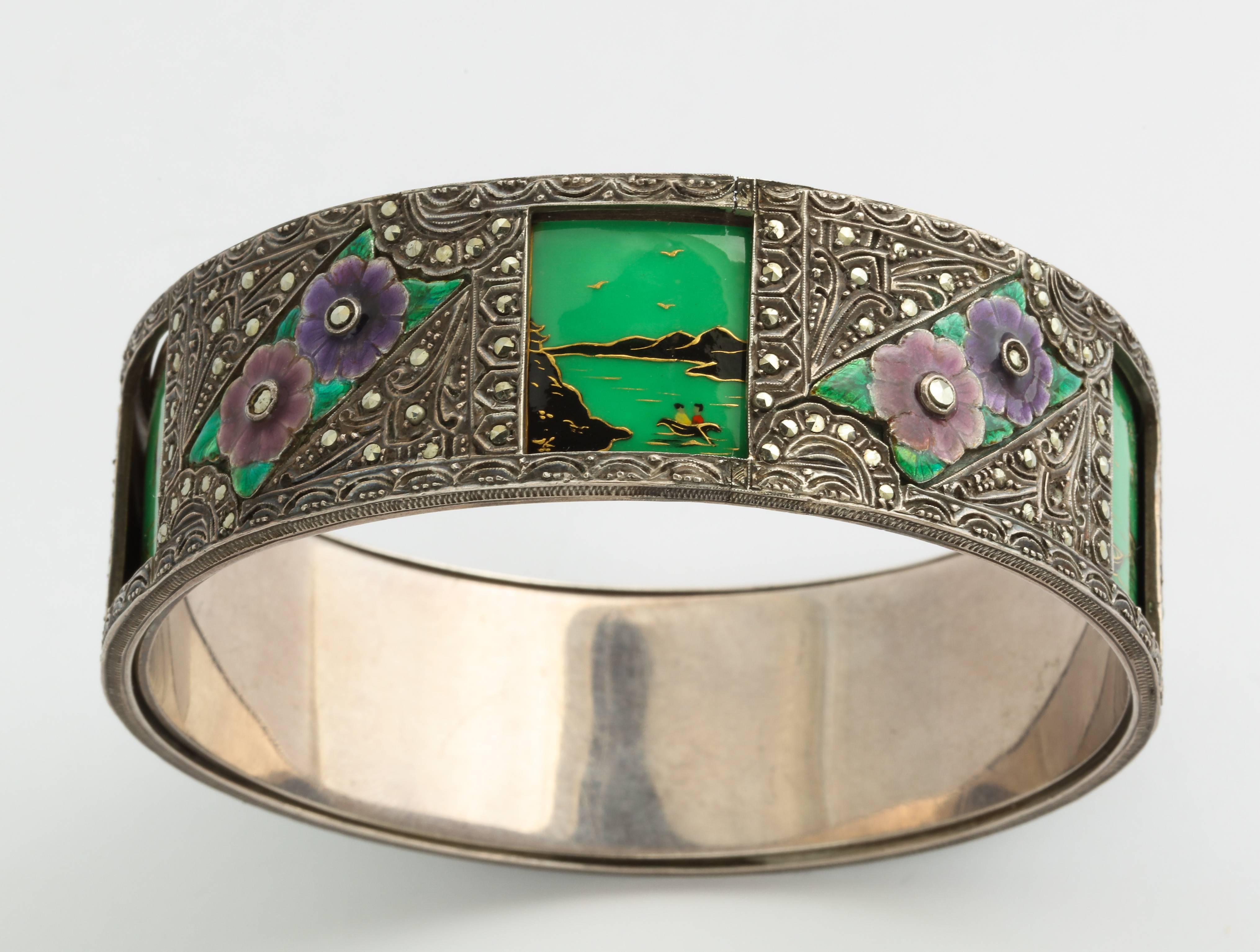 A very special Art Deco bracelet of silver, marcasite and enamel, made to wear somewhere between wrist and elbow, with a unique mechanism that lets you revolve the outer band of cut out windows, over a band of enameled scenes in color choices of
