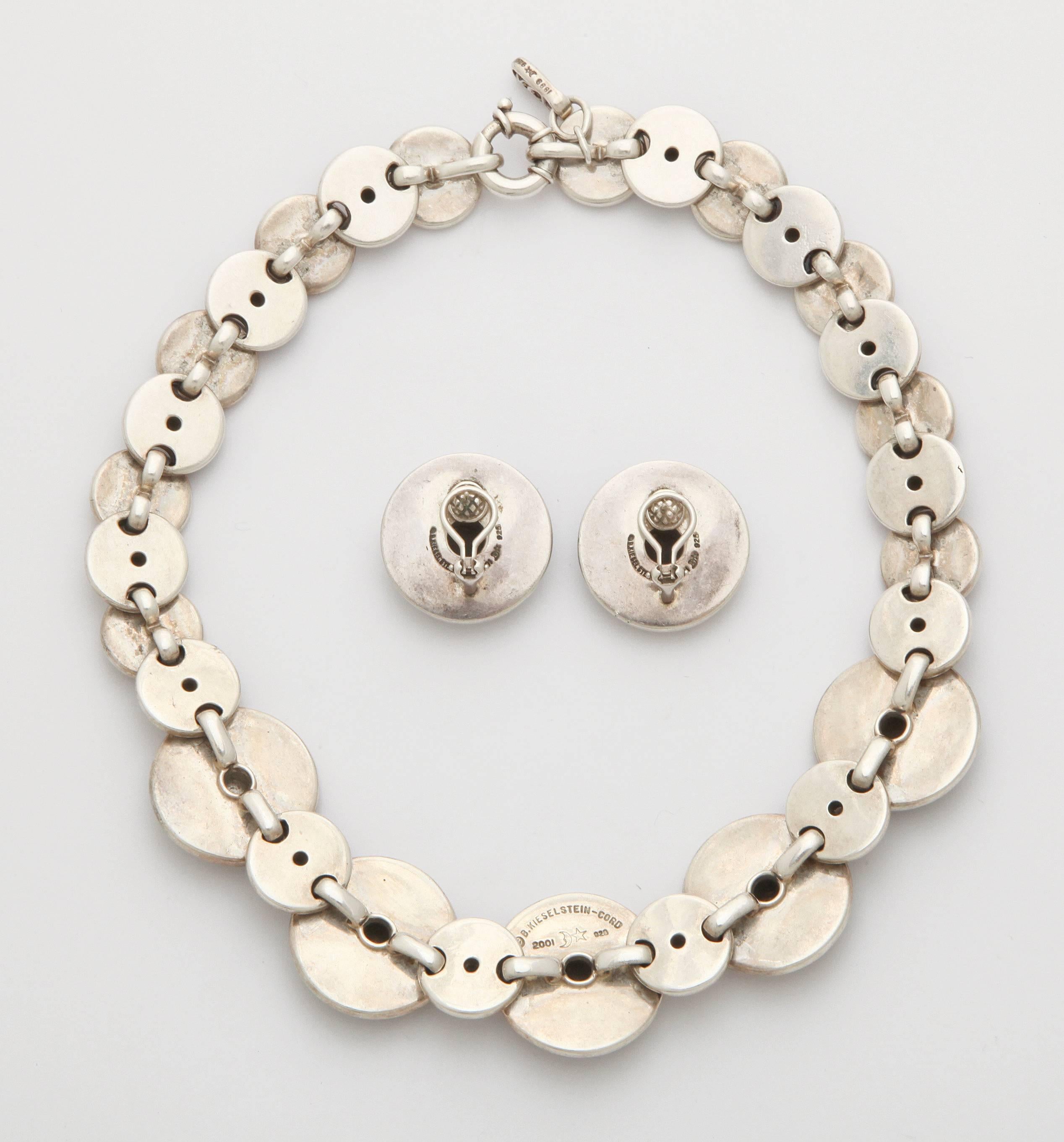 A bold and striking necklace with matching ear clips by award winning designer Barry Kieselstein-Cord, featuring substantial sterling silver discs inlaid with beautifully marbled tortoise shell. Necklace length of 18 1/2 inches, and ear clips of 1