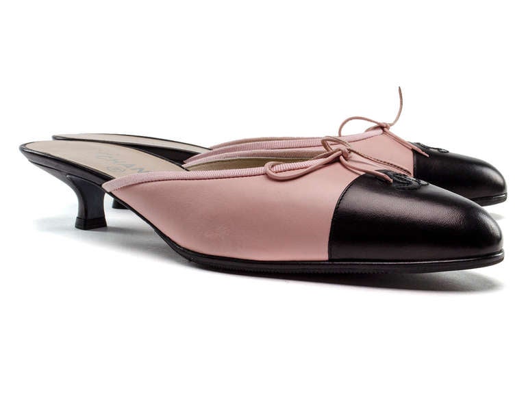 A hint of spring creates quite the allure with these Chanel mule heels! A black cap toe with 'CC' stitching, pink leather throughout the shoe with bow detailing, kitten heel. Heel measures approximately 2