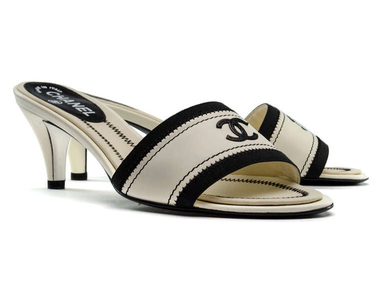 Just in time for summer these Chanel sandals will be the perfect addition to any sundress! Heels feature white leather throughout with contrasting navy blue details with iconic Chanel 'CC' logo on the front of the sandals in navy blue. Heel measures