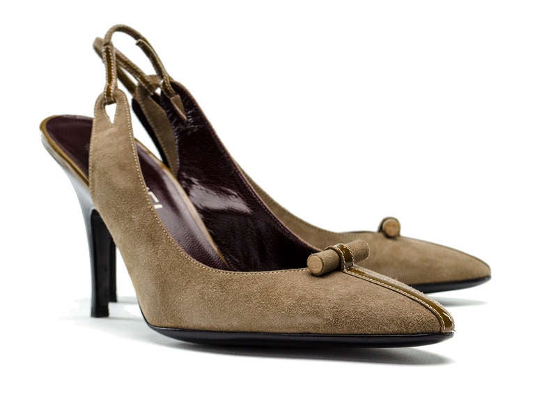 The perfect neutral! Chanel slingback suede heels in taupe are the perfect balance to any outfit. Featuring taupe suede throughout, patent leather detail at vamp with ivory stitching, slingback, stacked wooden heel. Heel measures approximately