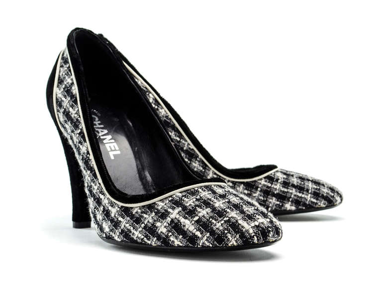Perfect for the office! These black & white Chanel tweed pumps will be sure to have your co-workers stopping in their tracks. These heels feature black and white tweed detail throughout, black velvet piping, round toe, black velvet covered heel.