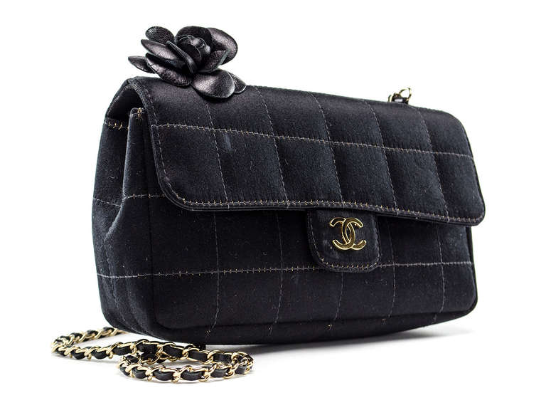 This Chanel Black Quilted Satin Camellia Mini Flap Bag is a rare and beautiful piece to collect. The unique chocolate bar quilted satin bag features a detailed leather camellia flower which is adored by Coco Chanel herself. The versatile leather
