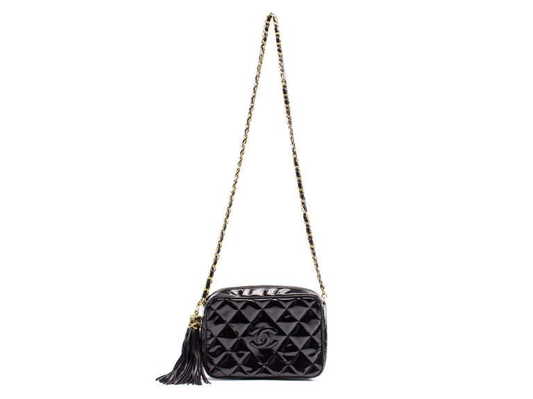 Why not make any ensemble effortlessly chic with this stunning vintage Chanel black patent leather crossbody? This stunning beauty is featured in black patent leather with gold hardware, zip top, iconic interlocking CC detail at front of the bag
