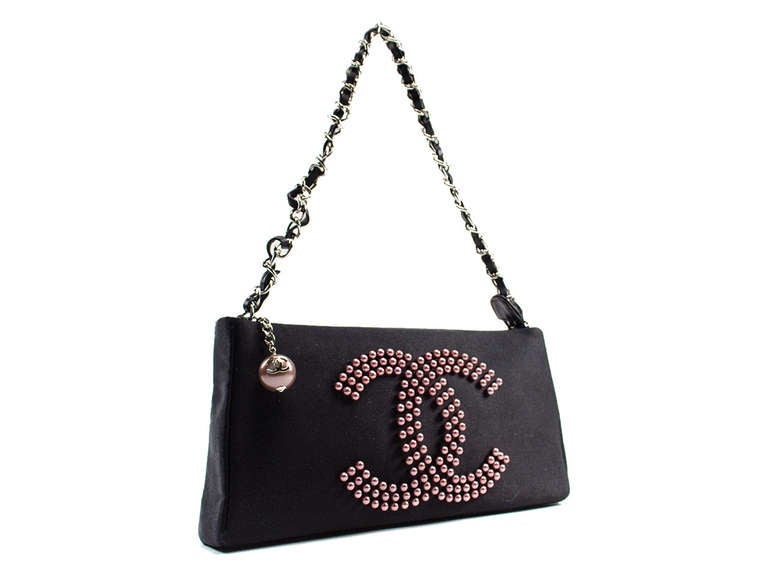 Perfect for a night out on the town! This Chanel bag features black satin throughout with a silver tone and black leather interlaced chain, interlocking CC detail at front in pink pearls with blush pearl pull zipper with Chanel 'CC' icon. Interior