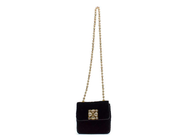 Make a statement in this one of a kind Chanel velvet evening bag. This bag features black velvet throughout, pearl & rhinestone detail at front of the bag, snap closure, pearl beaded chain. Interior features one zippered pocket.