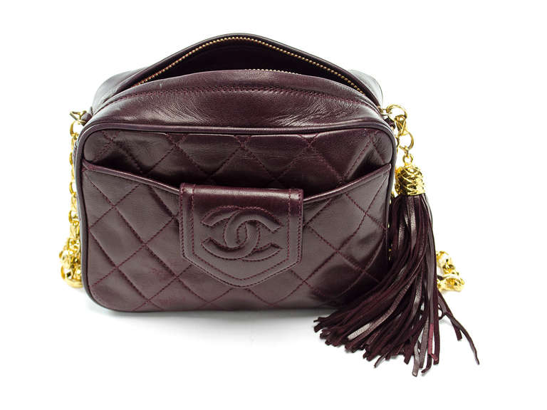 Add a dose of chicness to any outfit with this beautiful Chanel vintage burgundy camera bag. This bag features lambskin leather with quintessential diamond pattern throughout, iconic interlocking CC logo at front, tassel pull, gold tone hardware.