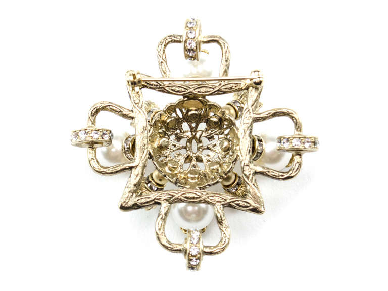 Extremely rare! Chanel brooch is done in an extremely hard to find brushed silver surrounded in faux pearls with interlocking 'CC' detail at the center of the brooch. Crystal detail in the underlay of the brooch makes this a standout piece.