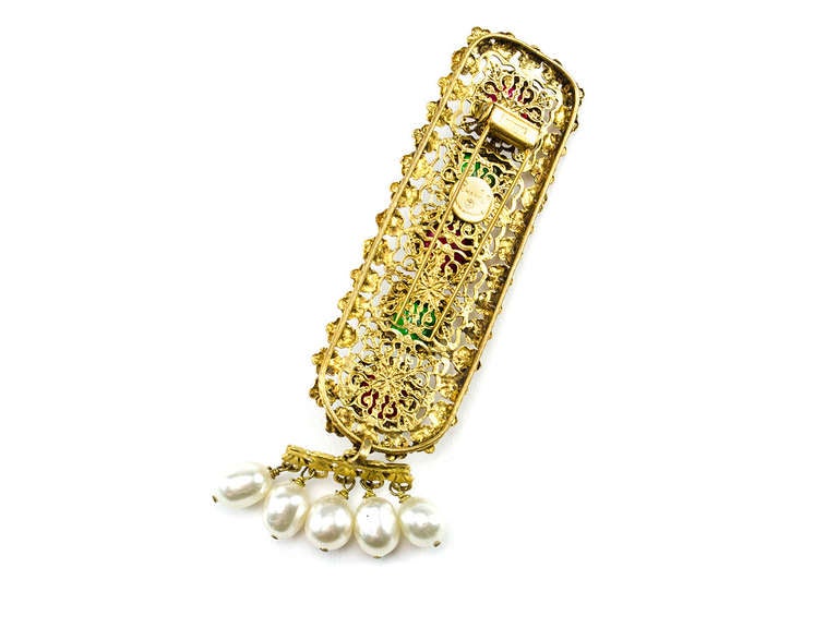Extremely rare Chanel piece that can be appreciated by the finest collectors. This stunning piece was crafted exclusively by Chanel Depose in gold tone hardware with intricate flowers surrounding the pin with faux pearls and red and green gripoix