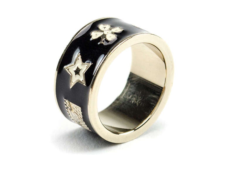 Part flirty, part cute this enamel bow ring will be sure to add a hint of playfulness to any outfit! This ring features black enamel with interlocking 'CC' logo, high heels, handbag, star, four leaf clover, flower and a bow. Fits a size 5-6