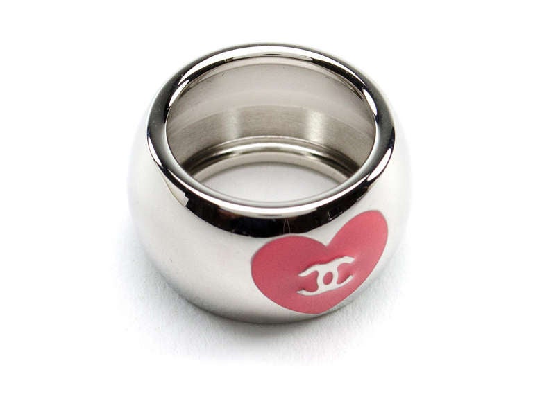 Absolutely adorable! Chanel silver tone heart ring features the iconic interlocking 'CC' logo in pink with the other side having a pink heart with interlocking 'CC' inside the heart. Fits a size 7-8 comfortably. 

Includes: Box.