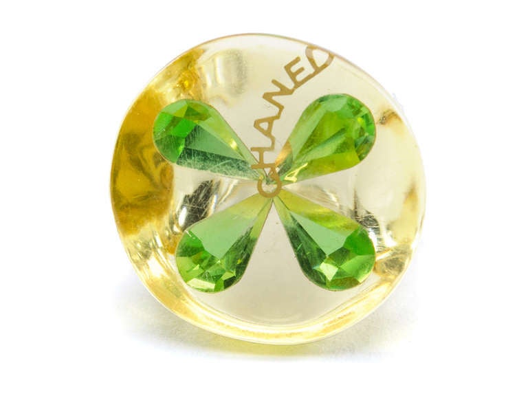 Add a little bit of luck to your life with this fun Chanel lucite four leaf clover ring! Ring features clear/yellow detail throughout with bright green clover at the center with 'CHANEL' written in gold. Fits a size 7-8 comfortably. 

Includes: