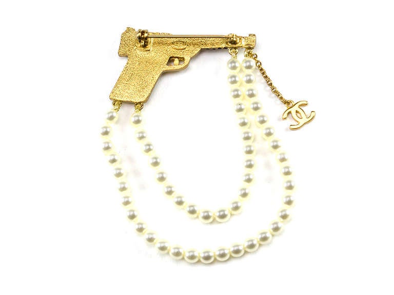 A little fierce, a little feminine this fun Chanel gun brooch will add an extra pep to your office step! Stunning details feature draped pearls, iconic interlocking 'CC' logo.

Includes: Box.

Measurements: 1.75