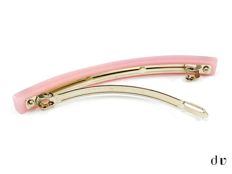 Pin your hair back with this darling Chanel hair clip. This hair clip is featured in pink lucite with crystal details and 'CC' logo in silver at each end.

Includes: Box.

Dimensions: 4.5