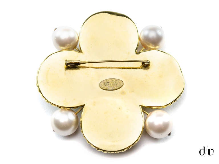 We absolutely love this Chanel vintage brooch that features poured glass detail in blue and green with pearl detailing throughout. Circa season 25.
