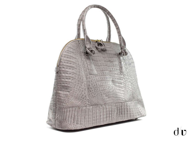 Extremely rare! Nancy Gonzalez satchel is perfect to carry everyday life essentials including a laptop or ipad. This bag is featured in a grey crocodile skin with two zipper pulls. The bottom of the bag has five protective feet to prevent the bag