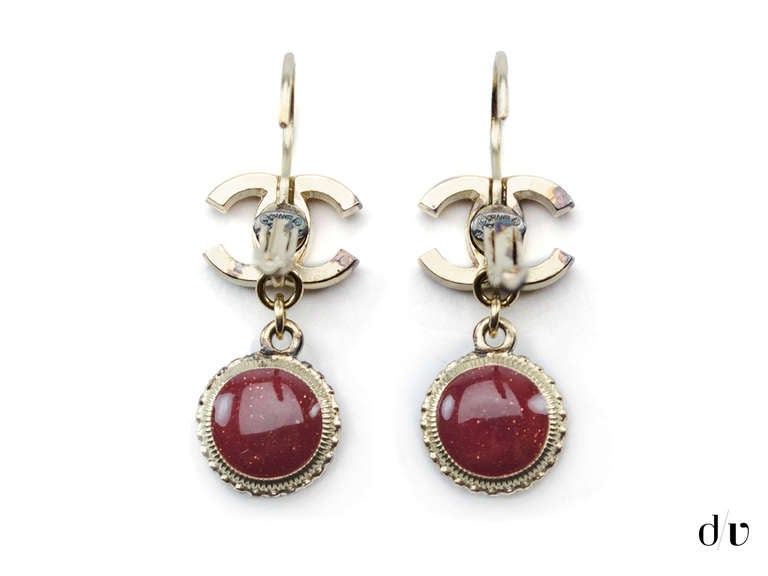 The perfect understated elegance in these Chanel vintage earring that features gold tone hardware throughout the outer with red poured glass at the center. Clip on style.

Measurements:1.25