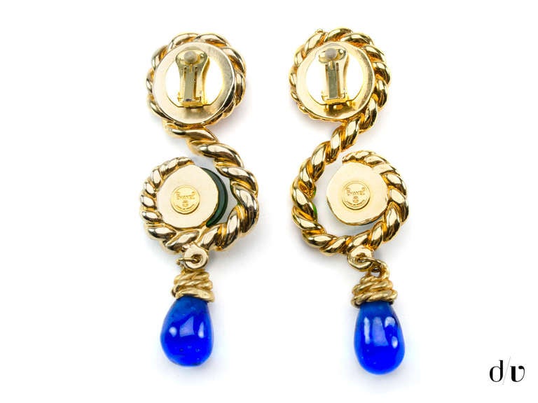 Extremely rare! Chanel gripoix earrings will be sure to make a statement in any ensemble! These earrings are featured in gold tone hardware in a braided 'S-Shape' with pink and green poured glass with an a poured blue glass tear drop.