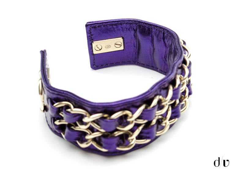 Make a statement in this Chanel purple metallic leather cuff! This cuff features purple leather throughout with a brushed silver tone hardware with link detail and interlocking 'CC' detail at closure.

Includes: Box.

Measurements: 8.25