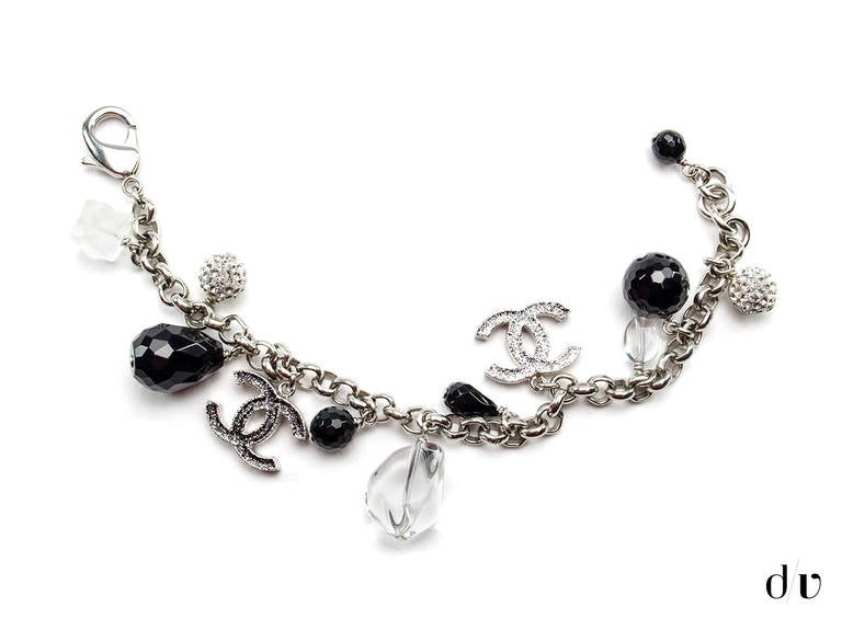 A touch of elegance with this Chanel bracelet featuring black and white crystal detail throughout. This charm bracelet features the iconic interlocking 'CC' charm and other black, white and clear crystal beading detail. Hook closure.

Includes: