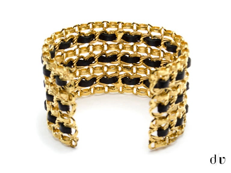 A hint subtle and a hint chic this Chanel cuff is your perfect everyday essential! This cuff features gold tone hardware with black leather intertwined  and easily cuffs on the hand.

Includes: Box.

Measurements: This cuff measures 2.5