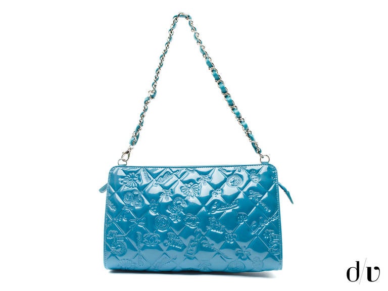 We love this playful Chanel pochette  in the lucky charms design in teal patent leather. Exterior features a zip top, clips on the top and can be worn as a bag or a clutch. Interior features one pouch pocket.

Measurements: 9.25