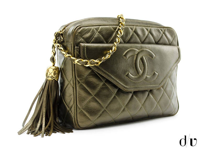 Keep your essentials in this Chanel vintage camera bag! A perfect go to in a bronze lambskin leather, gold tone hardware, quintessential diamond pattern throughout, one interior front pocket. Interior features one interior pouch pocket and one