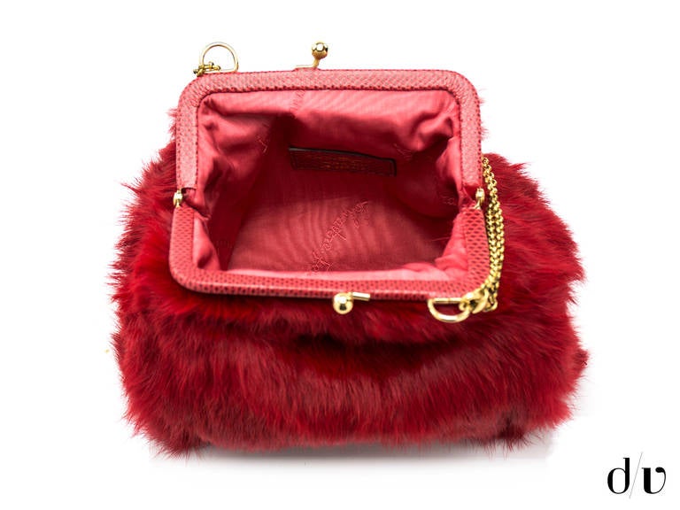 Make a statement in this great Salvatore Ferragamo red rabbit fur bag. This bag features a turtle on the front, kiss lock closure, small chain strap.