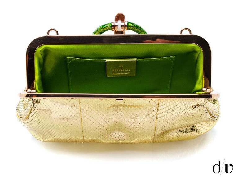 Feminine, fashionable and attractive, this golden colored handbag by Gucci is an ideal pick for your evening outings. The single grab handle is green in colour, as is the python on the flap. It gives a unique style to the bag, making it very