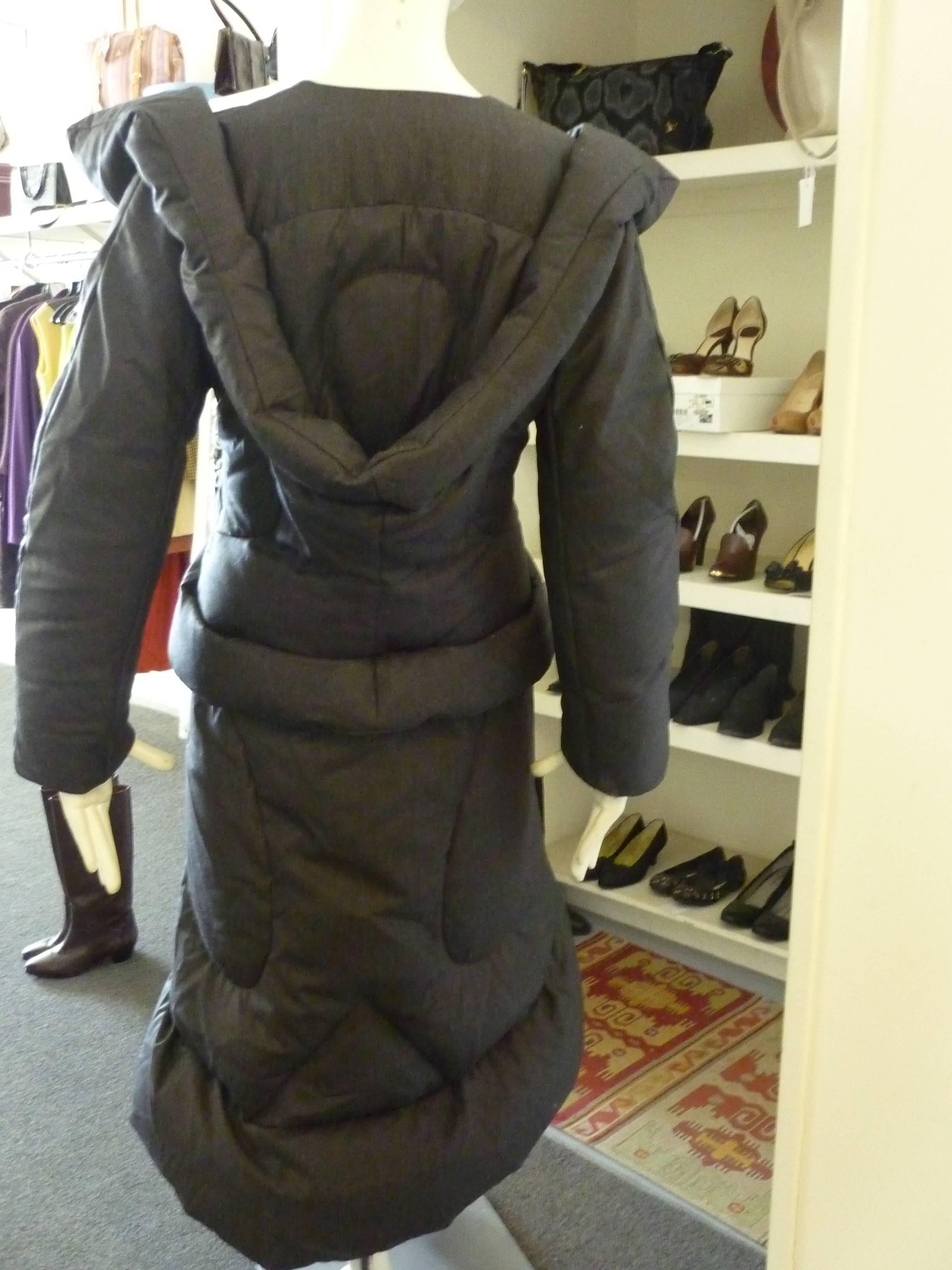 A work of art with the exagerated shoulders; faux hood and waist. This is the famous down filled puffer coat in dark grey.

The coat was made in Italy and has three eye and hooks for closure, but the styling calls for bottom exposure.

A