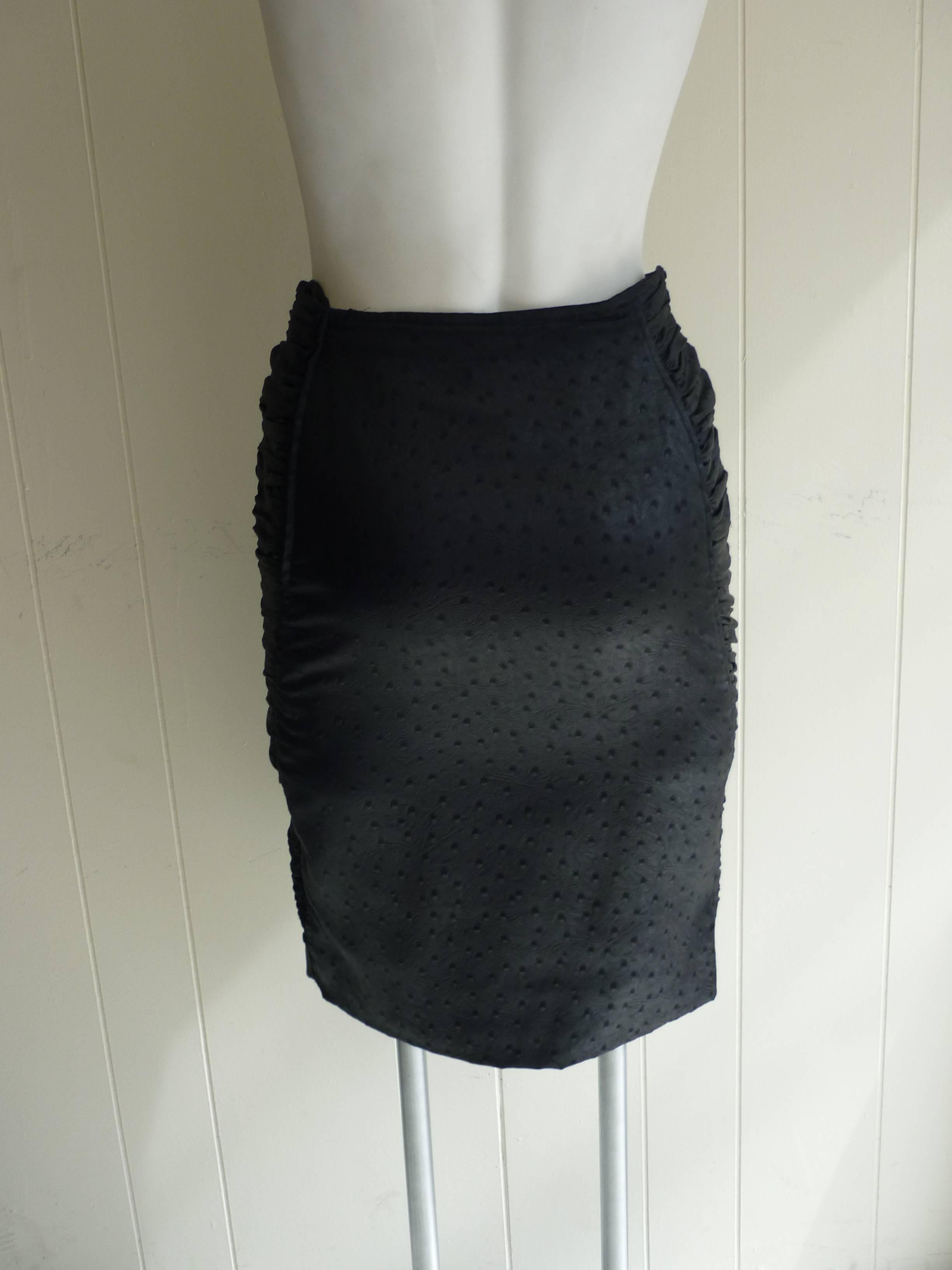 At first glance it looks like leather, but this is a cloth ostrich print pencil skirt. The sides are ruched to a point at the hem and closure is by a zip which is just off the side.