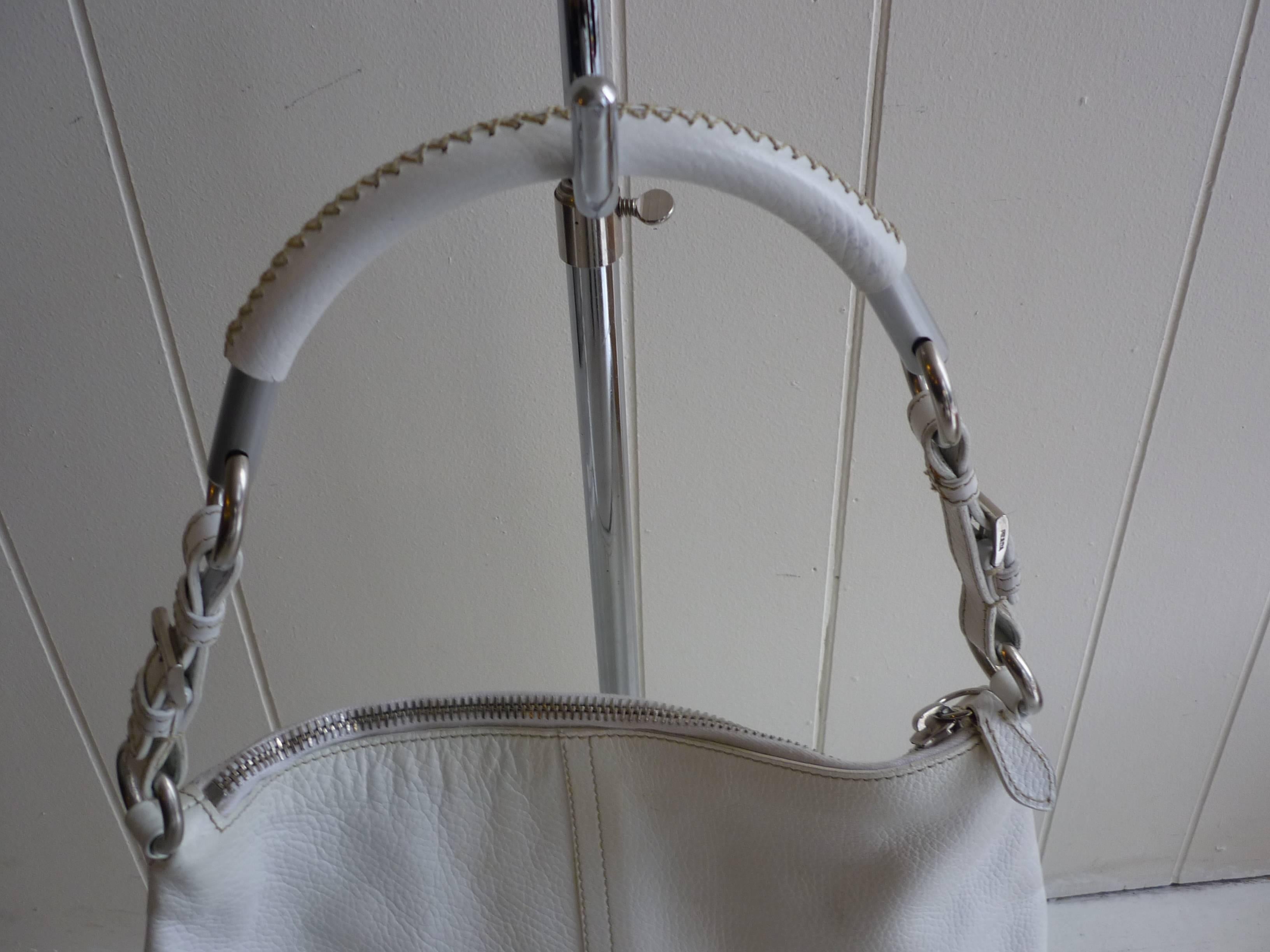 Very nice soft sided bag with a metal leather covered semi-ring handle which is connected to a 