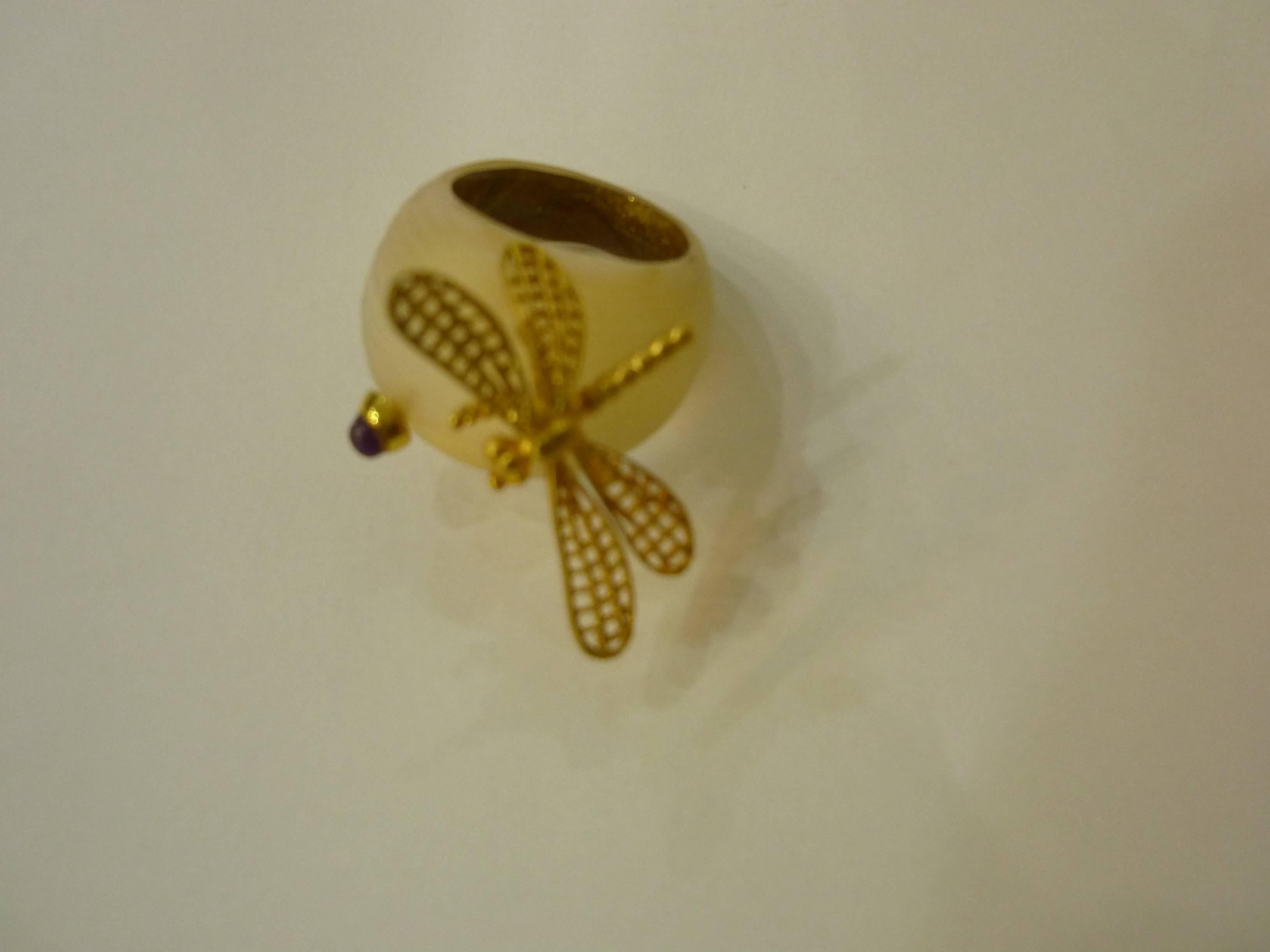 Lovely lucite dragonfly ring with a small cabochon. It is a transparent reflective gold color with gold-tone butterfly and cabochon. The interior has a gold gilt look.