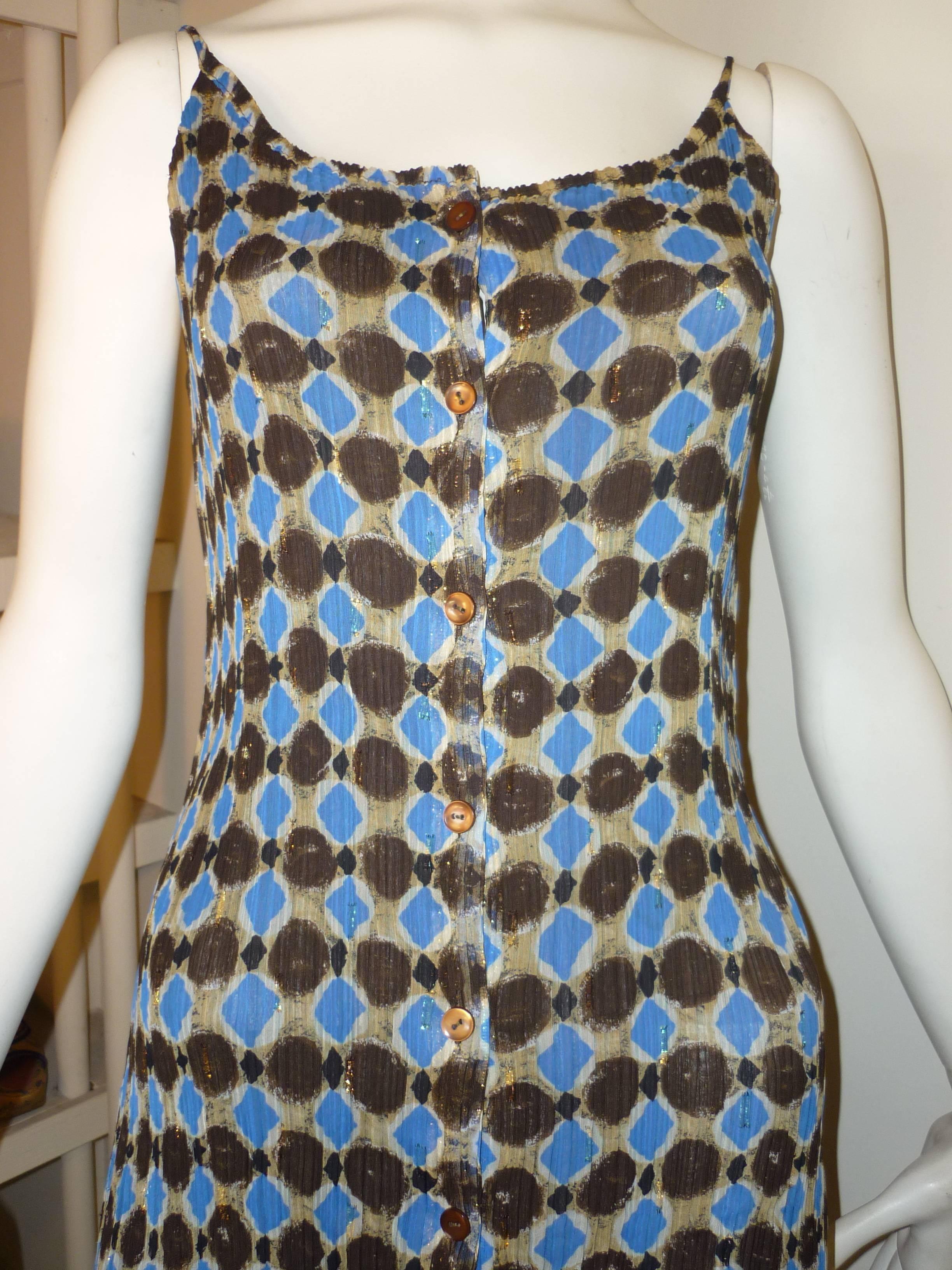 Perfect for the summer, this dress has an interesting diamond and circle print with a gold lurex thread running throughout.

It is not a Pleats Please dress but has a similar feel.

The dress has buttons from top to bottom, and a solid brown