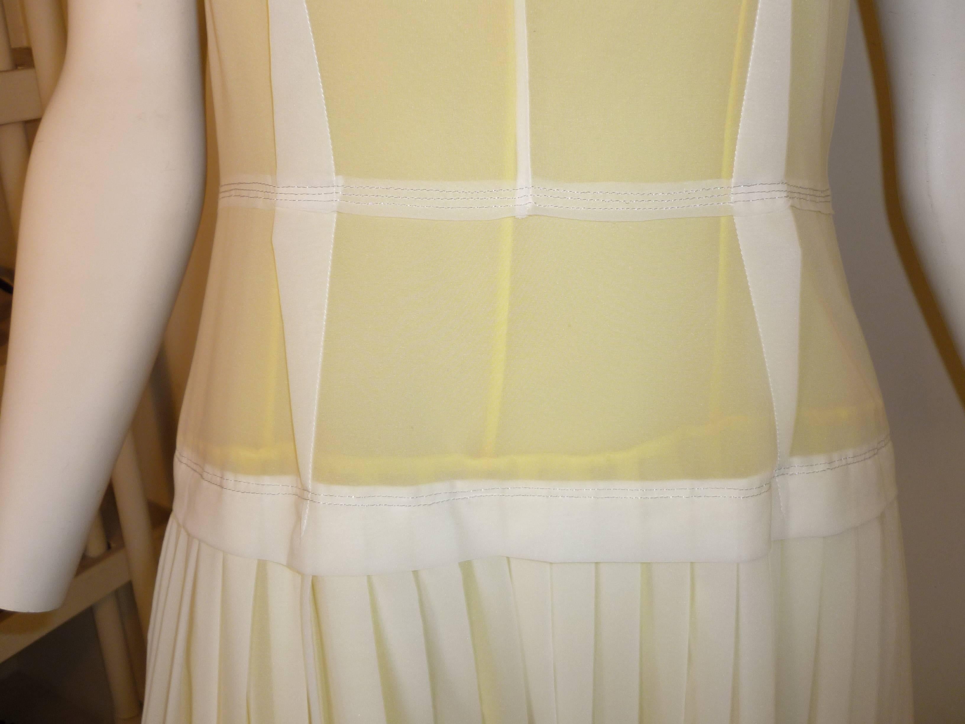 Delicate dropped waist dress made of 81% nylon and 19% elastane, it has two lining one beige and the other yellow.

There are several darts on the top half of the dress; a band at the waist and the skirt is soft pleated.