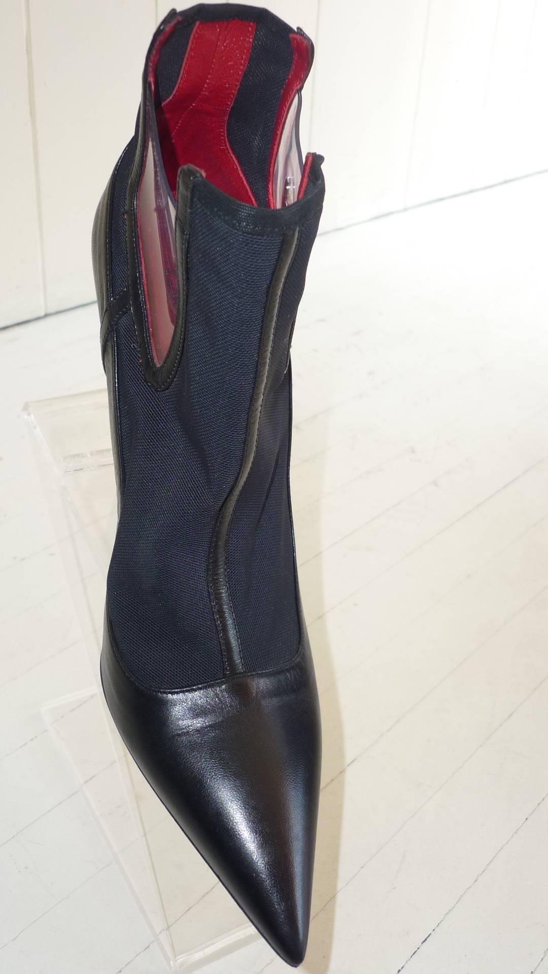 Never worn stiletto boots in black leather with plastic see through sides and spandex mesh. 

The dagger logo features on the plastic, as well as the sole.

The heels are 4