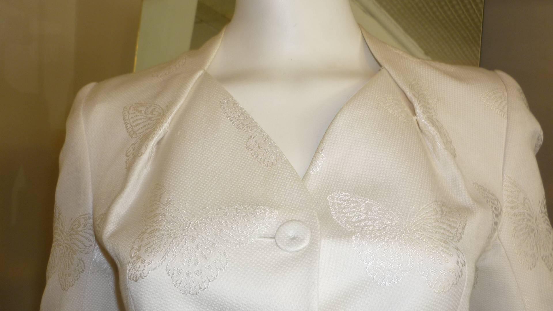 Such a lovely suit in ivory cotton 67% viscose 33%. The material is a pique with butterfly designs. The buttons are covered in the same material and look at collar dart feature.

The hem of the jacket is weighed down for a superb fit.