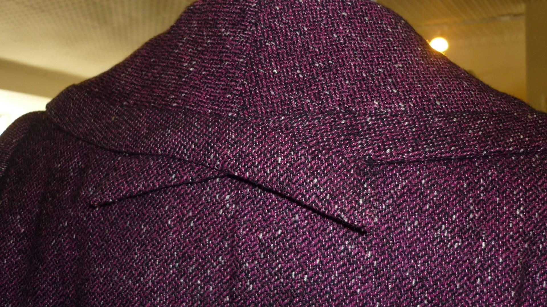 Such an elegant suit fashioned in a mainly burgundy tweed with black and white specks. The details are magnificient from the collar, to the slash pockets with a false flap, and the tiny slits on each sleeve (see pictures).