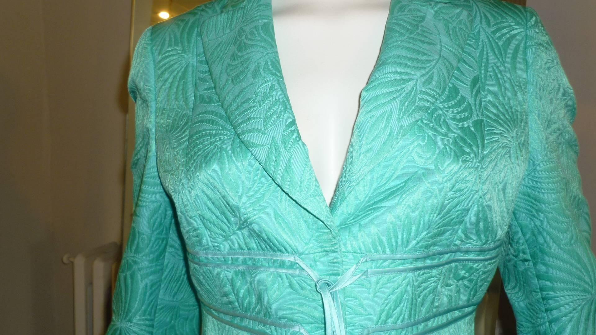 Vibrant green 70% cotton and 30% silk jacket with silk leaf raised embroidery design.

There is a lovely satin band detail throughout and closure is by three snaps and  laniards.