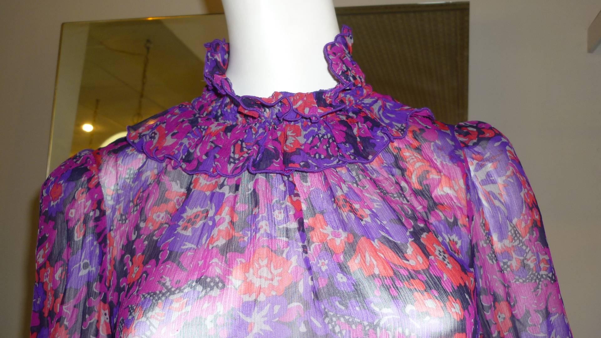 Purples, reds and blues are the dominant colors in this lovely dress with a high ruffle collar; ruffled sleeves and a swag skirt.

There is a 20s feel to this dress.

Closure is by two buttons on the back.