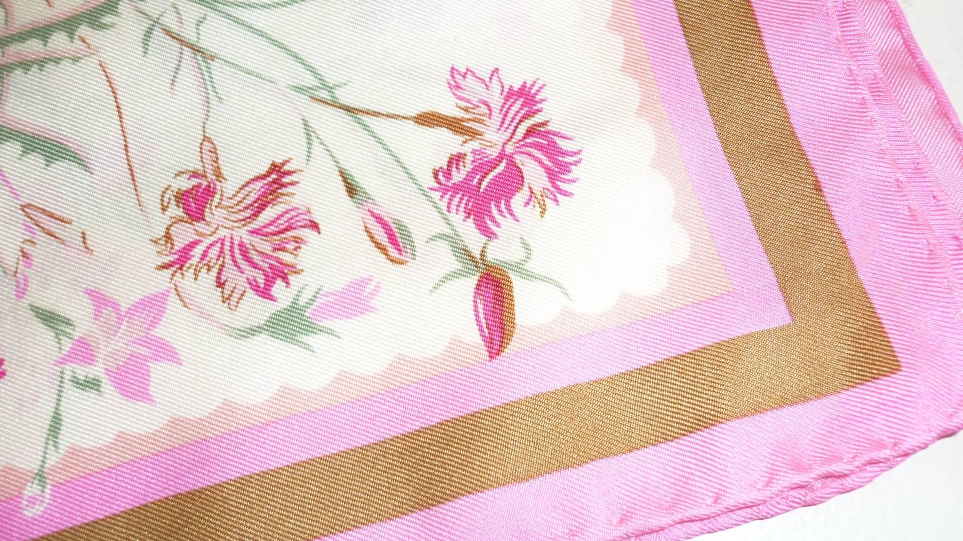 Very nice plant and abstract design silk scarf, with the predominant colors being pink, sage and white.

The dges are rolled and the care tag intact.

There is a small defect on what of the borders (photo), and this is reflected in the price.