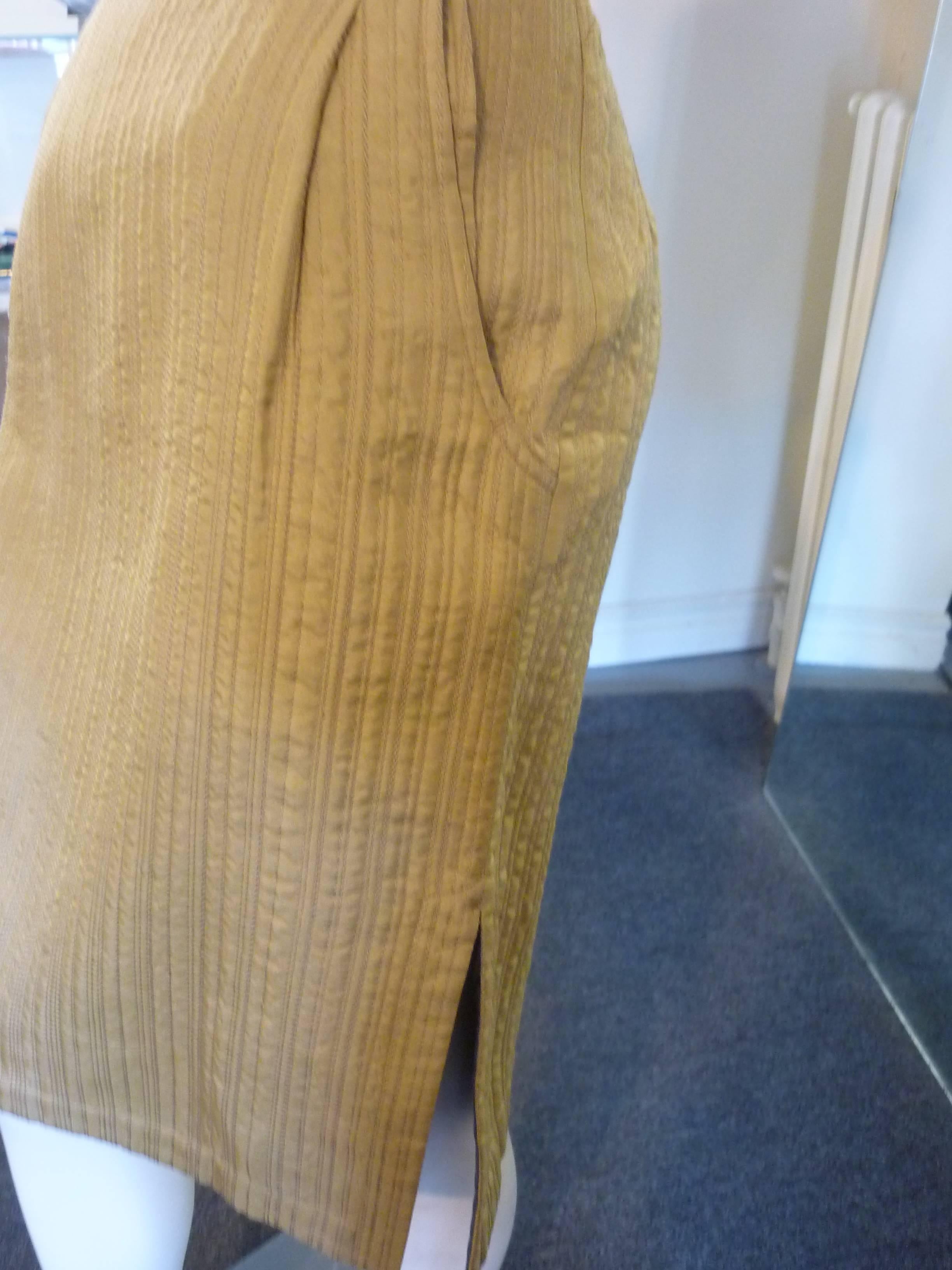 Gold maize tan stitch quilted silk skirt with side slits, slit pockets and grey lining.