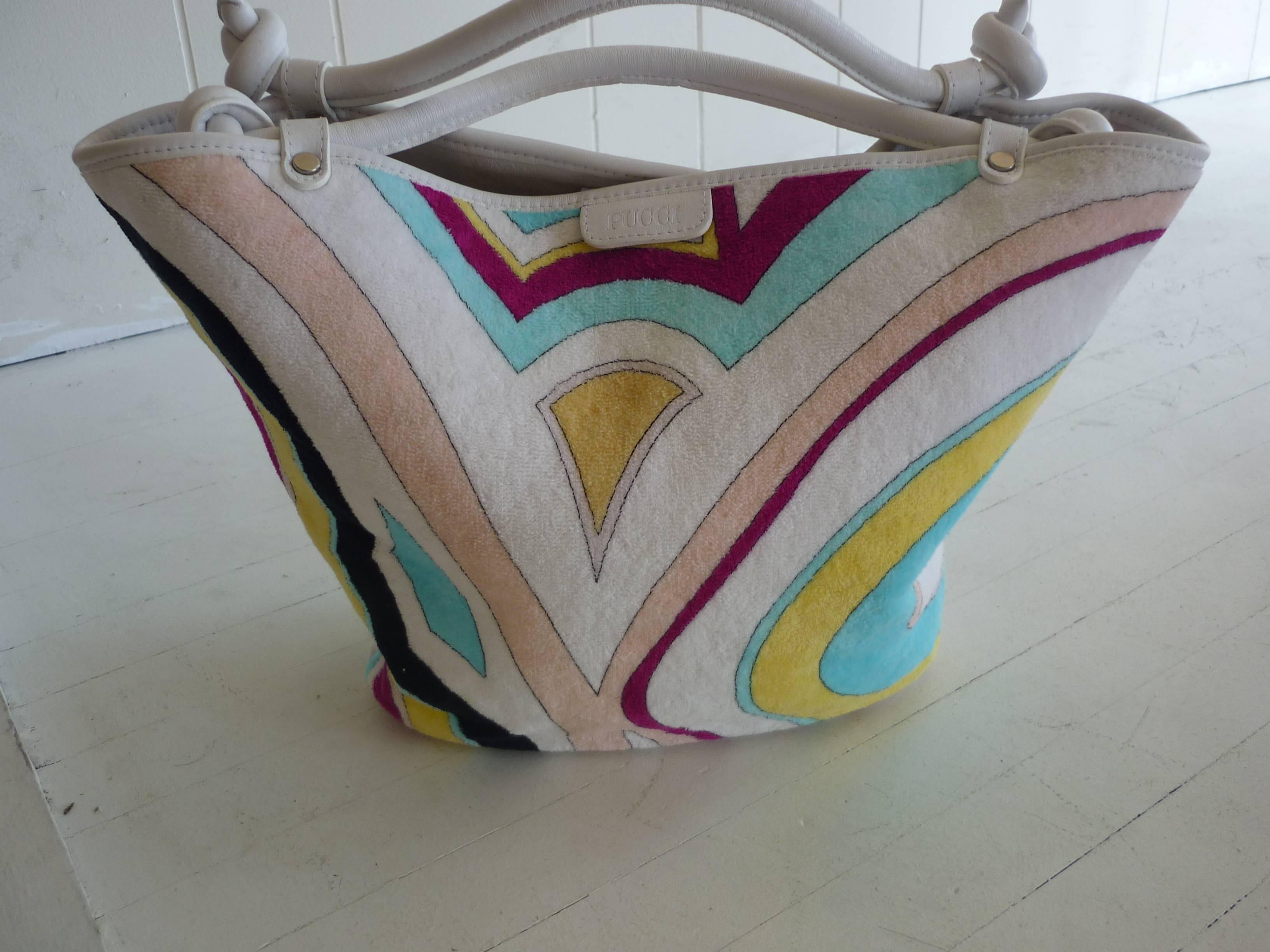A very attractive white background and multicolor deco patterned bag which make an ideal summer and beach bag.

The bag is trimmed in white leather, including knotted straps (3 inch drop) and a white lining; there is a zipped interior pocket and