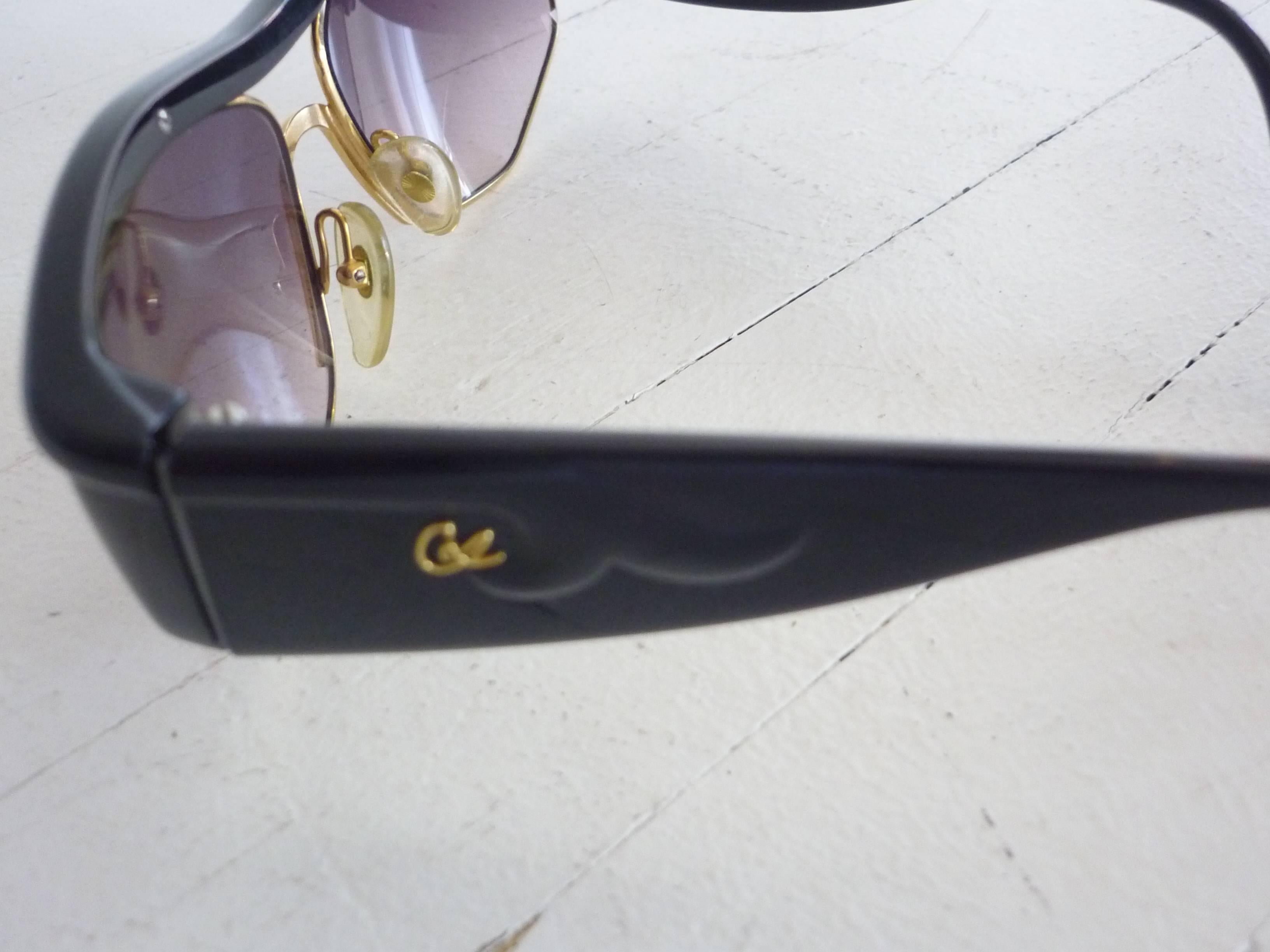 The frame is in black Optyl with shaded lenses rimmed in gold metal; the arms wide, and the CL logo in raised gold on each arm.

These sunglasses were made in Austria. I will send them in a quilted satinee case, but it is not the original.