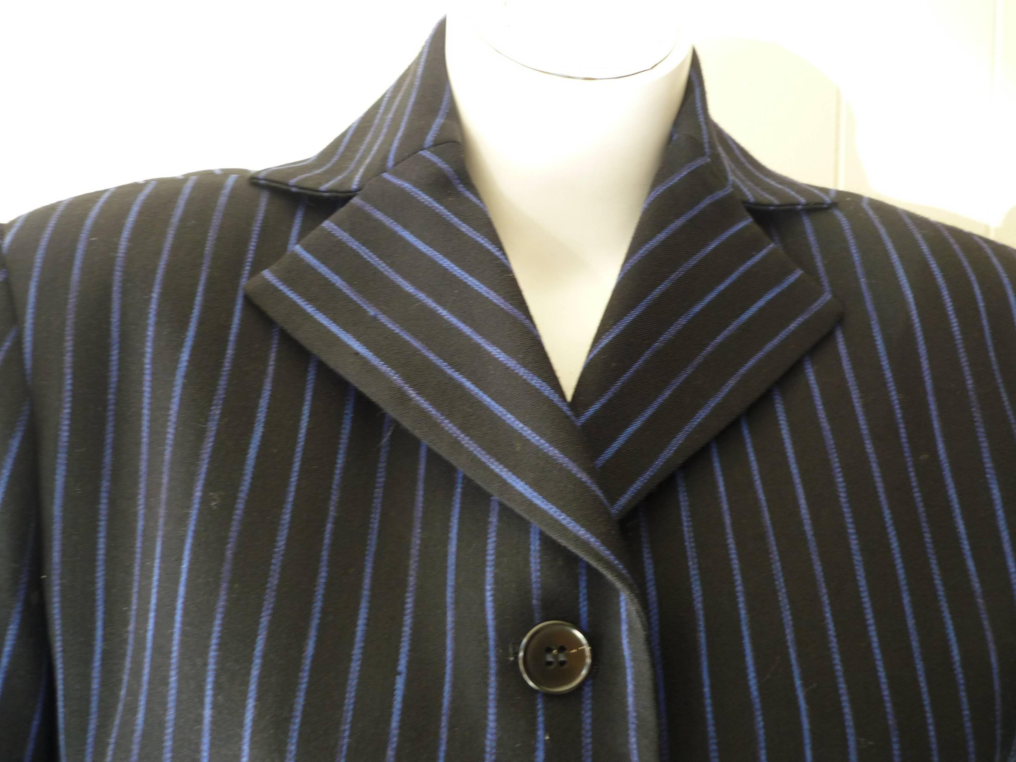 Black and blue pinstripe pant suit with wide pants, high waist and slight dropped crotch. The jacket is nicely tailored wih slit pockets; three button closure; a half belt and there a nice curved hem in the front.

There are a couple of small