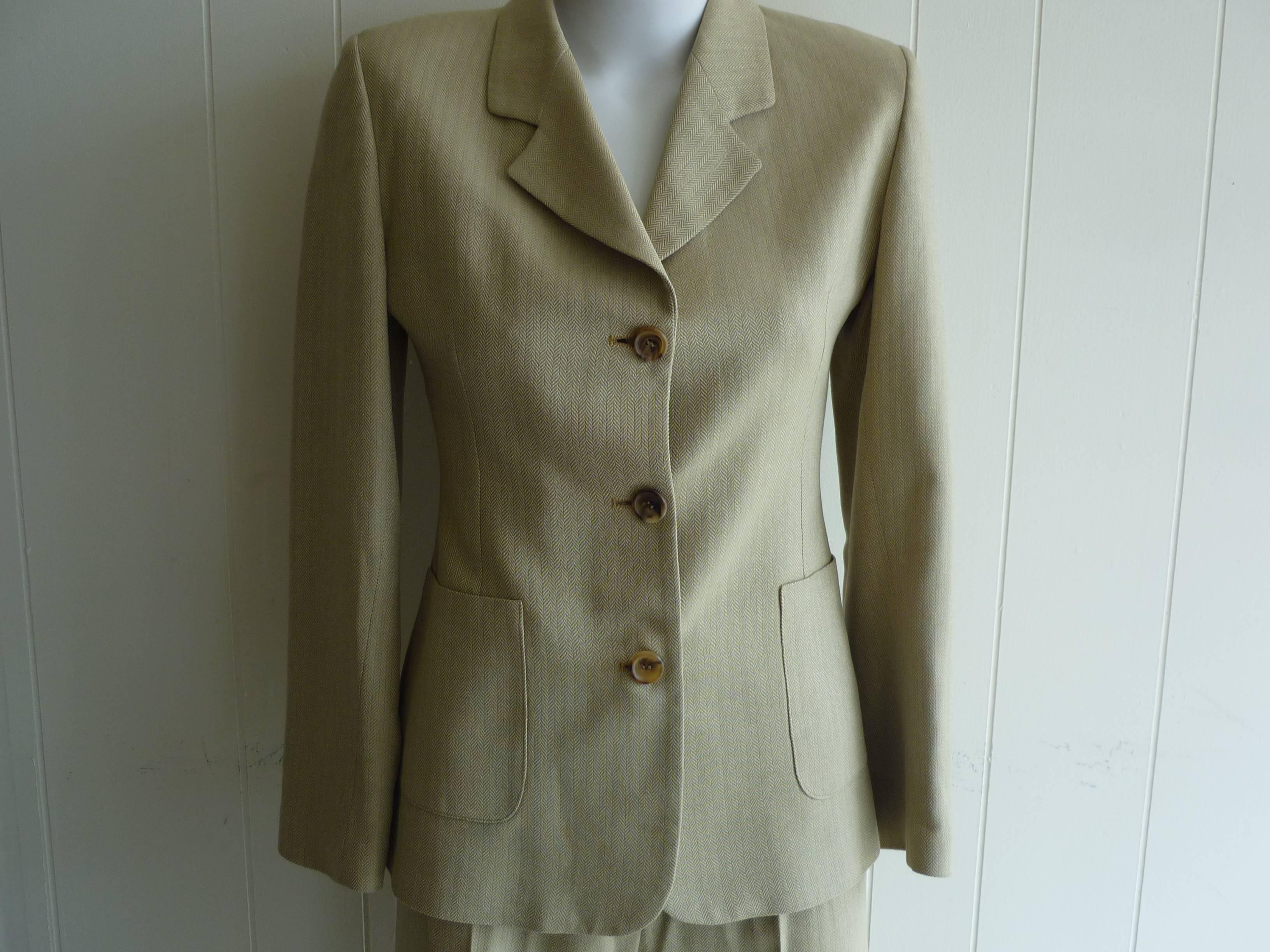 Wonderful herringbone pattern with a logo lining. The jackets has two pockets on the front and 3 buttons on  each cuff.

The pants have belt loops; a front zip and button closure, and a middle crease on each leg.

This suit will never go out of