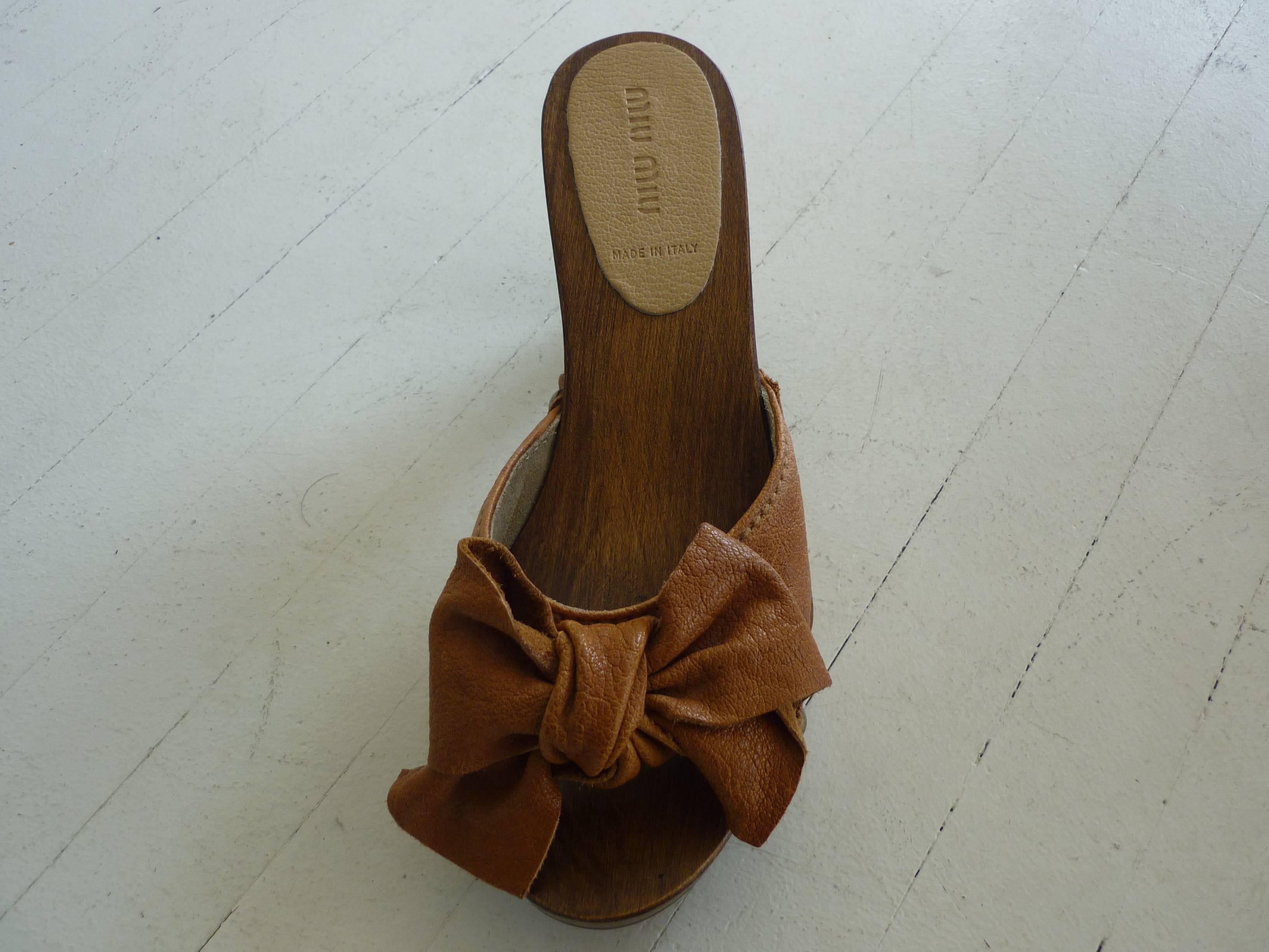 Nice solid wooden base and heels with bowed and stud embellishments. These sandals are in excellent condition.

3