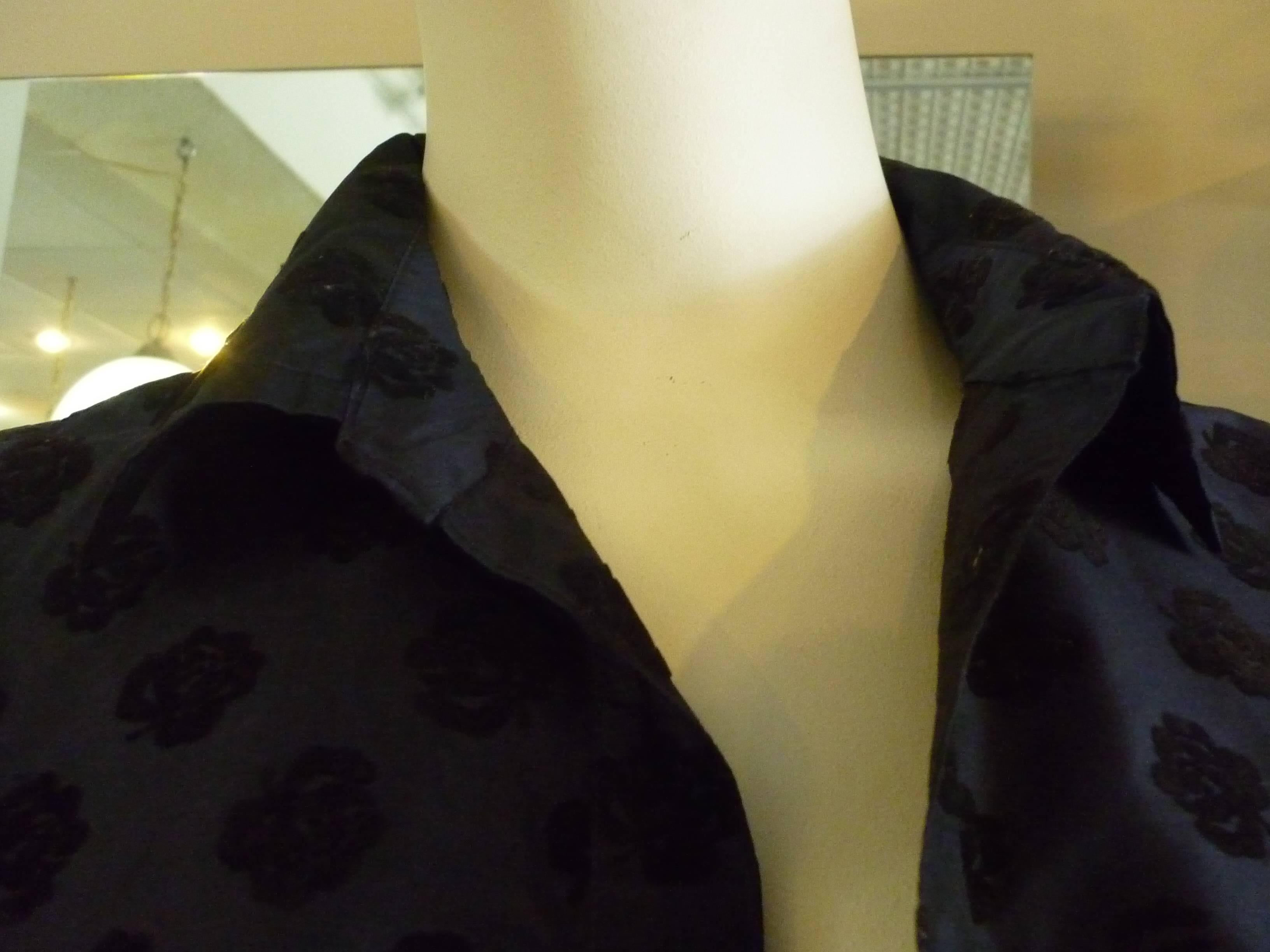 Nice weight silk with black floral velvet relief, this jacket is worn open over a dress or a collarless top. The button on the cuffs are weaved cord, and there is a breast pocket.

It is a nice example of Mizrahi's earlier designs.