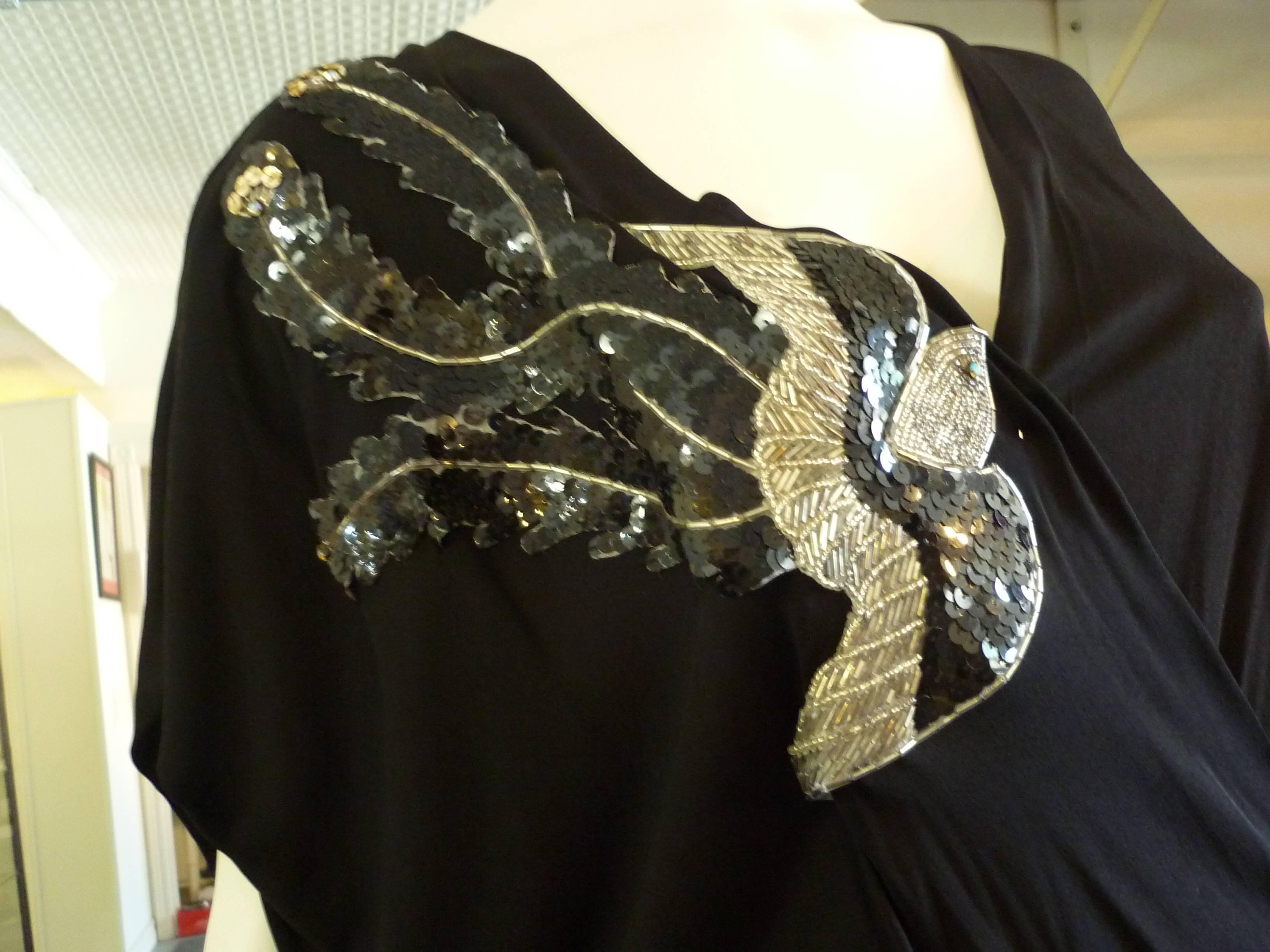 Probably a 1980s dress, but with a 1930s look. This crepe jersey dress has a wonderful sequin and bead bird decoration; a blouson back; wide bat-like sleeves and an attached half belt.