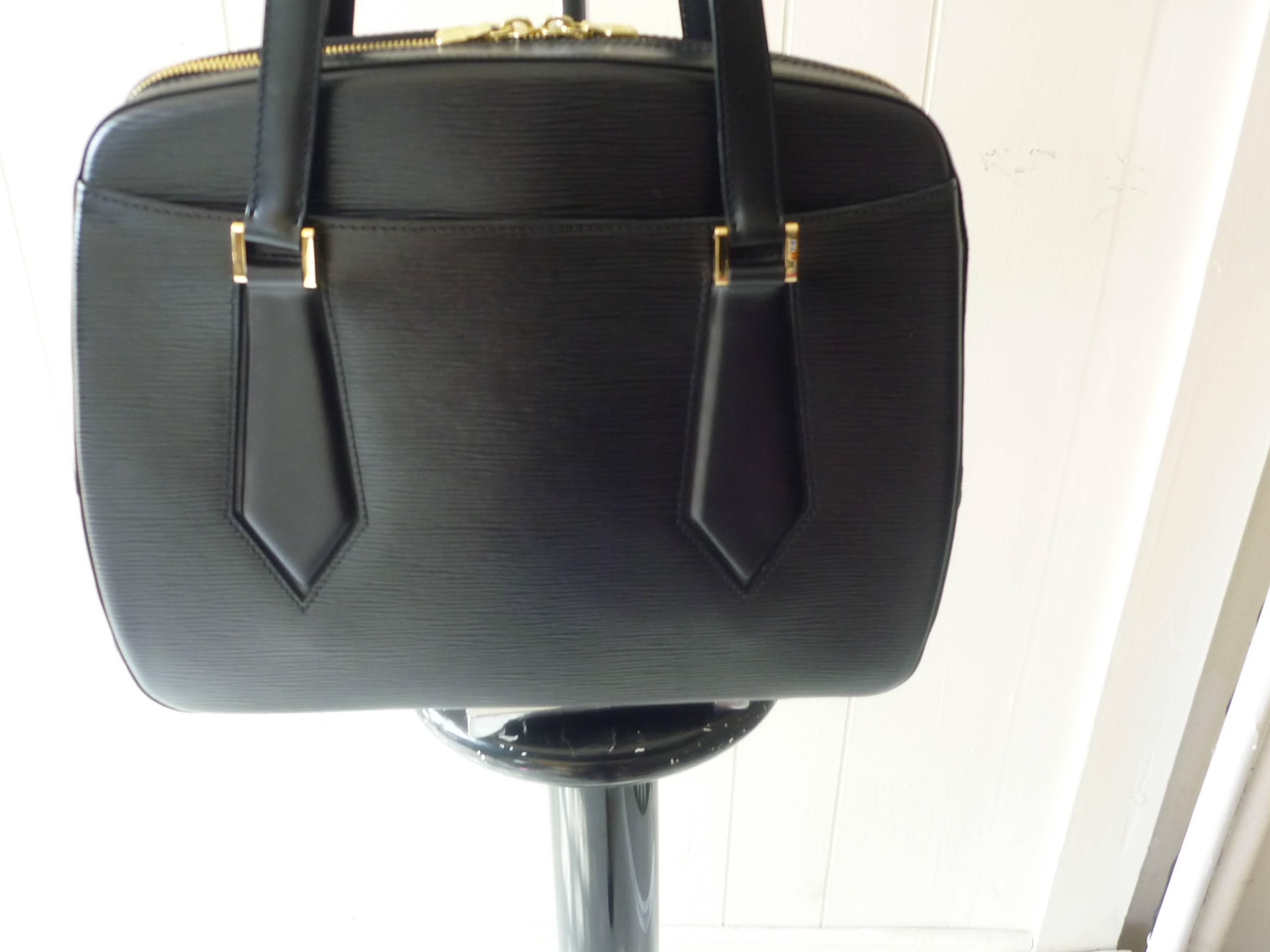 This bag is in wonderful condition. It is has a name shape and the straps are generous enough to be worn comfortably over the shoulder.

There is an open inside pocket, as well as an outside one; nice gold hardware; a top two pull zip closure, and